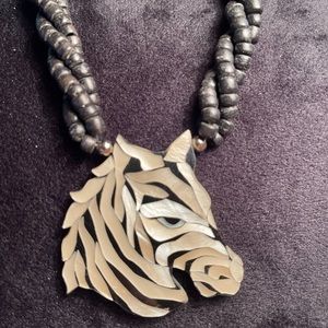 Black beaded chain holding acrylic zebra